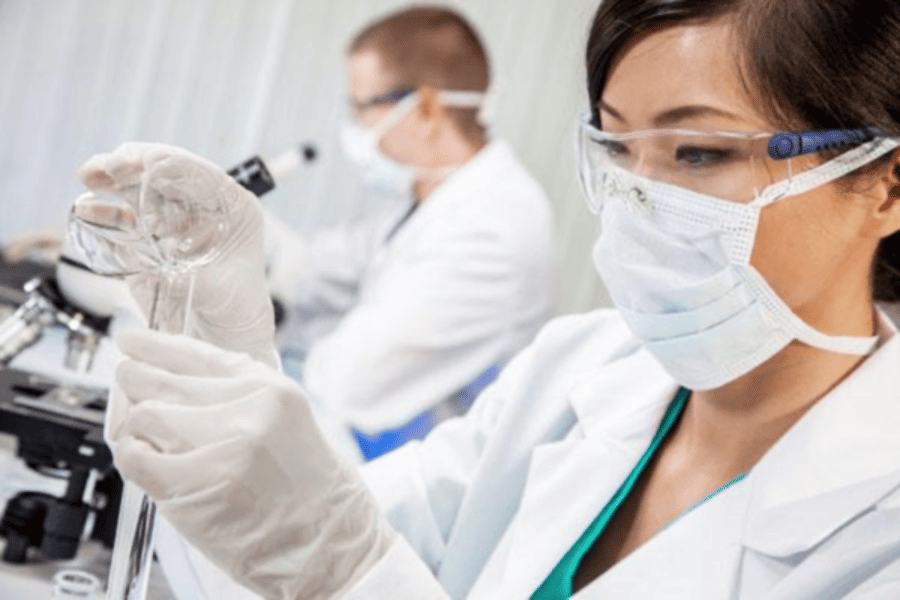 Laboratory professional preparing a specimen for pre-employment drug testing as part of employee screening and onboarding.